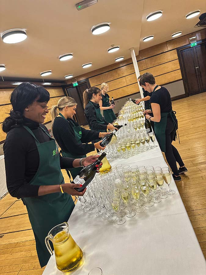 kates kitchen service staff pouring sparkling wine